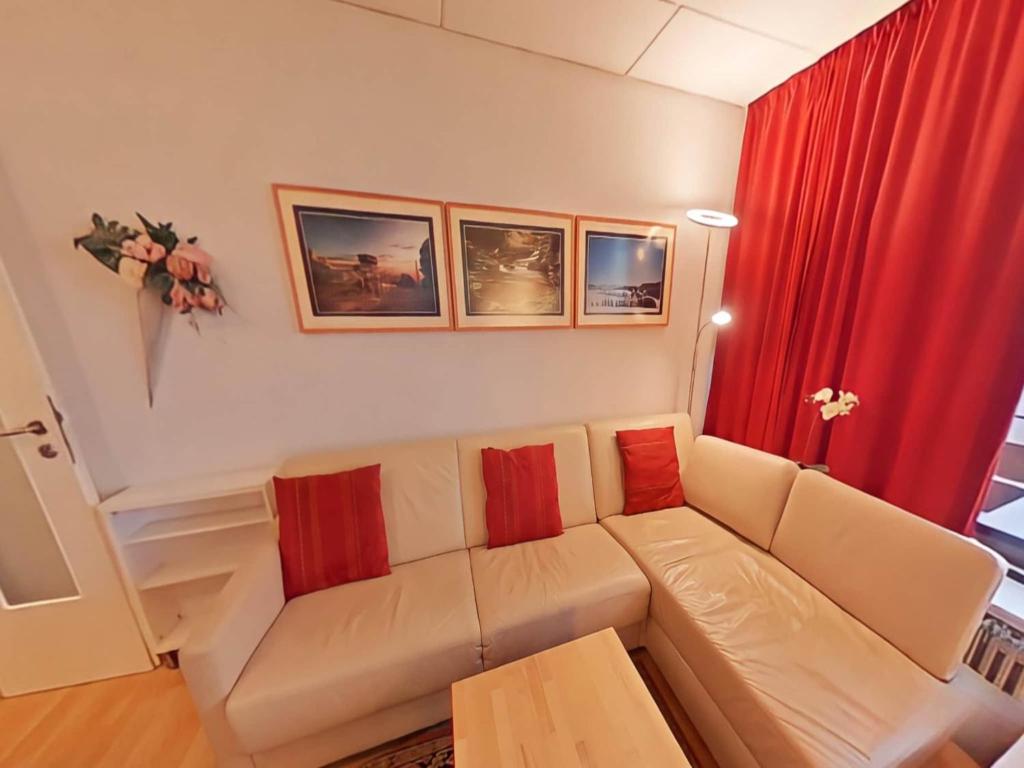 a living room with a white couch and red curtains at Appartement Peter in Freyung im Bayerischen Wald in Freyung