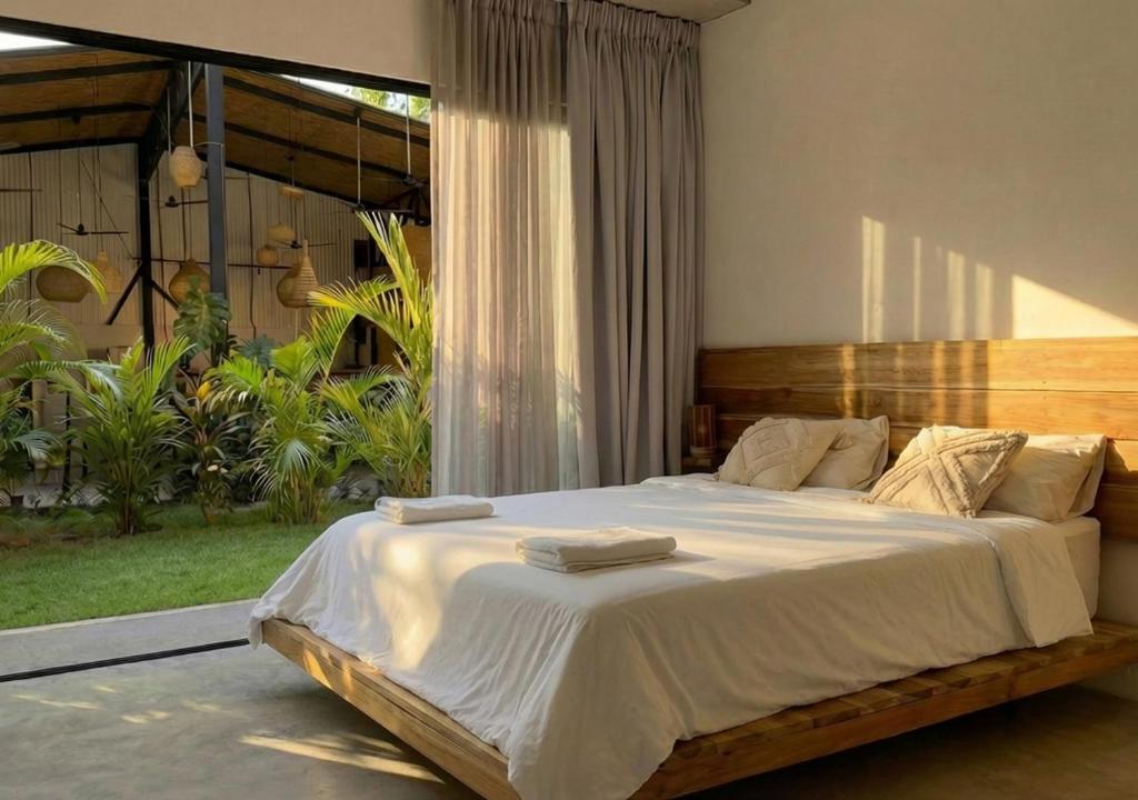 a bedroom with a large bed with two towels on it at Aduana House in Santa Teresa Beach