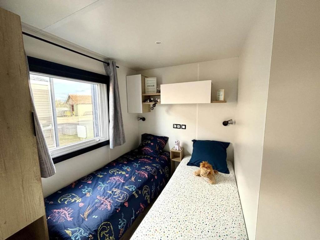 a dog sitting on a bed in a tiny house at Mobilhome in Saint-Gérons