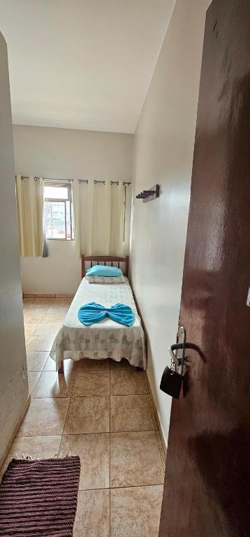 a bedroom with a bed in the corner of a room at Hotel Monarca Paracatu in Paracatu