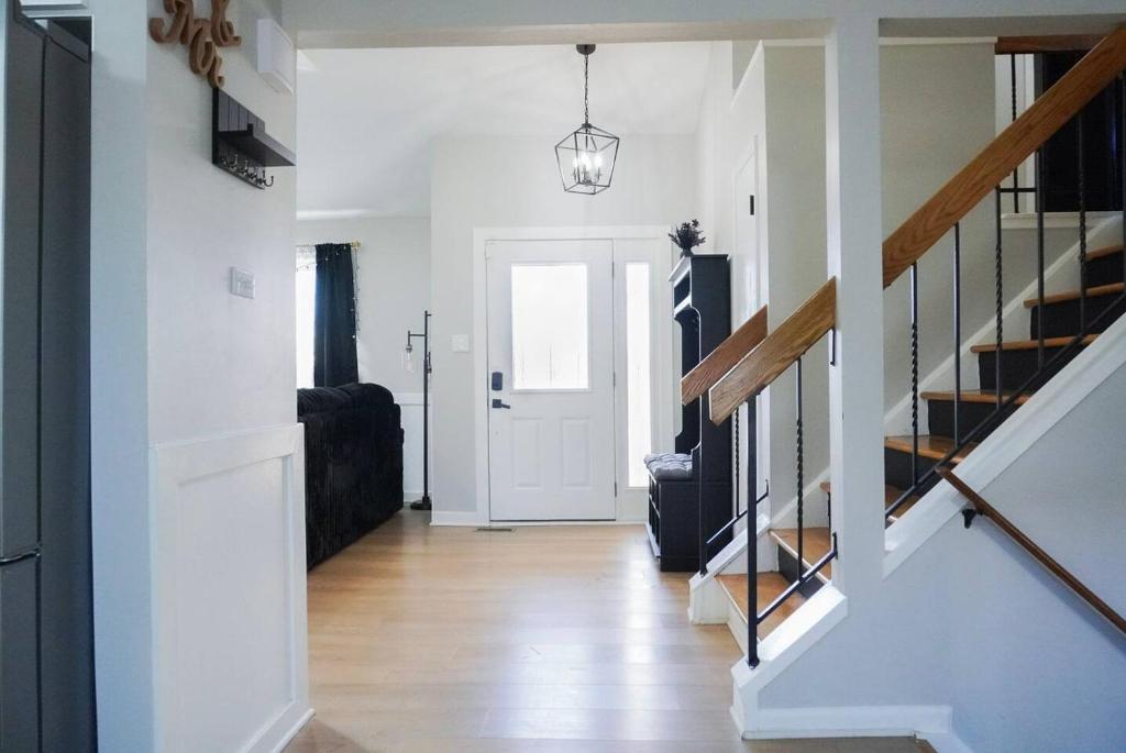 a hallway with white walls and a white door and stairs at Jacuzzi Cul de Sac Home in Country Club Hills