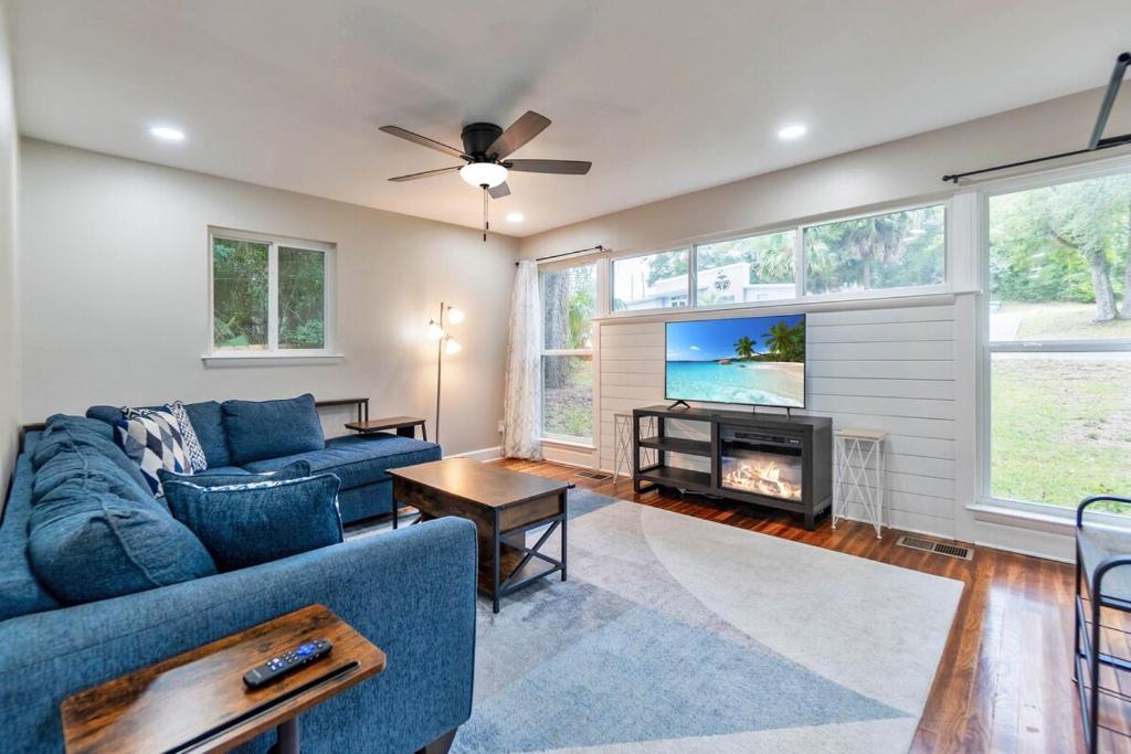 a living room with a blue couch and a tv at Hill House- Centrally Located, close to everything in Pensacola