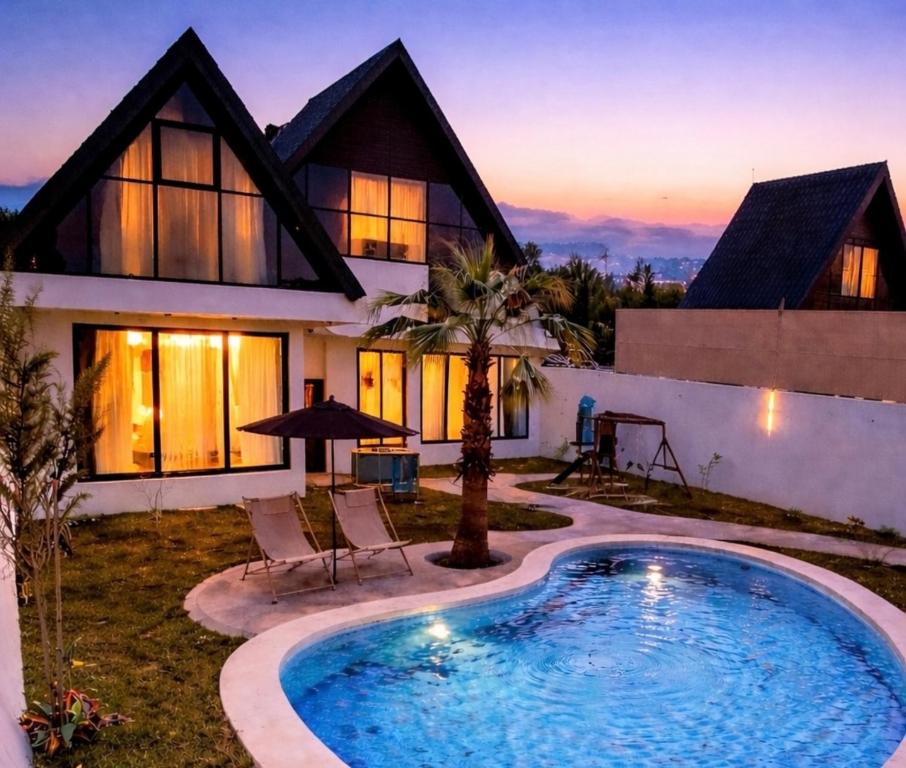 a house with a swimming pool in front of a house at اكواخ ساوثرنز in Ḩaḑram
