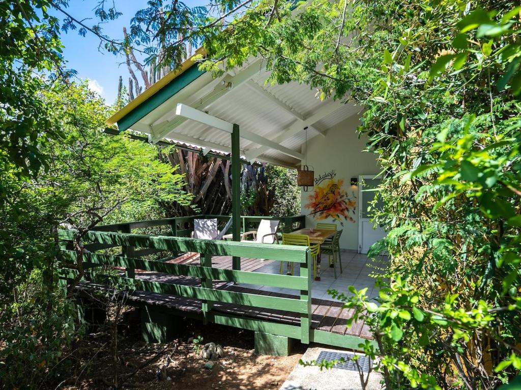 a patio with a wooden fence and a table at Trupial - The green flamingo in Willibrordus