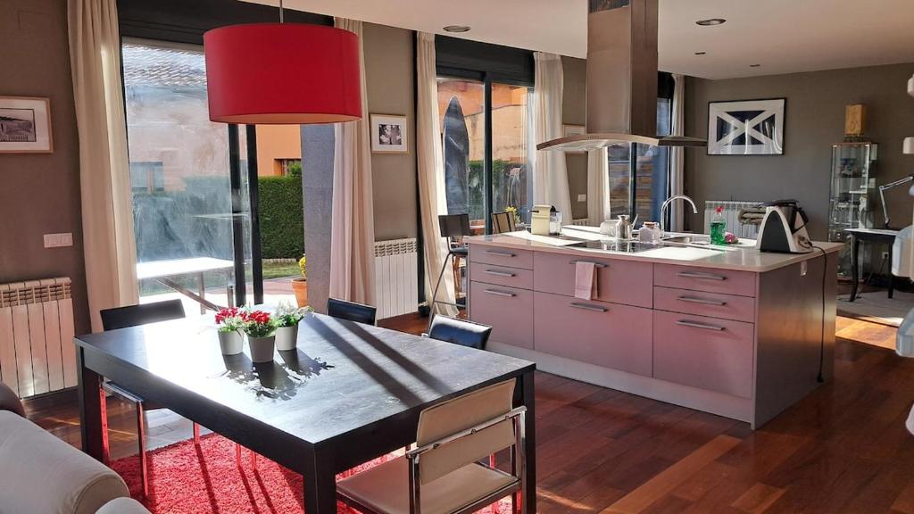 a kitchen with a table and a dining room at Unique and special loft in Sant Joan de les Abadesses
