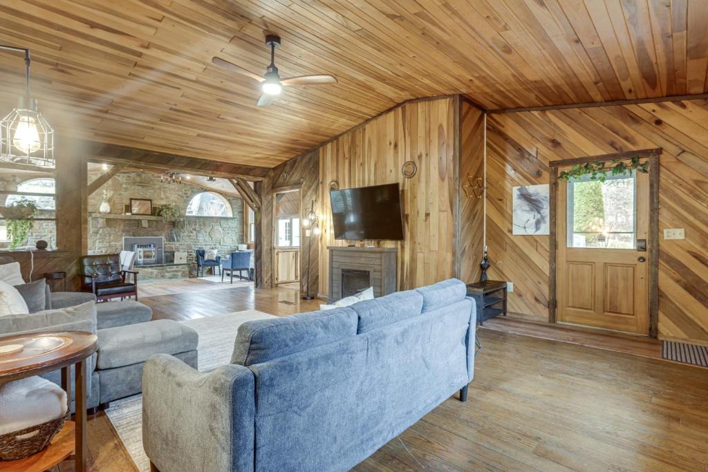 a living room with blue couches and a fireplace at Great for Groups! Spacious Melcroft Home w/ Deck in Melcroft