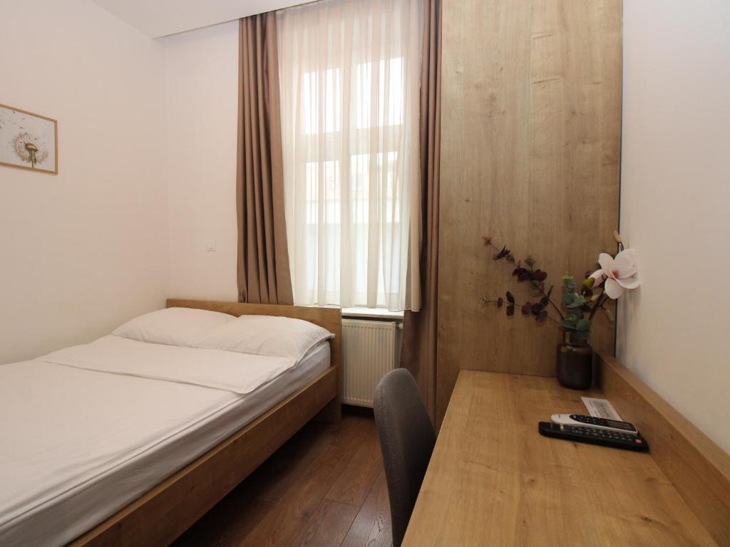 a bedroom with a bed and a table and a window at Vila Mila in Sarajevo