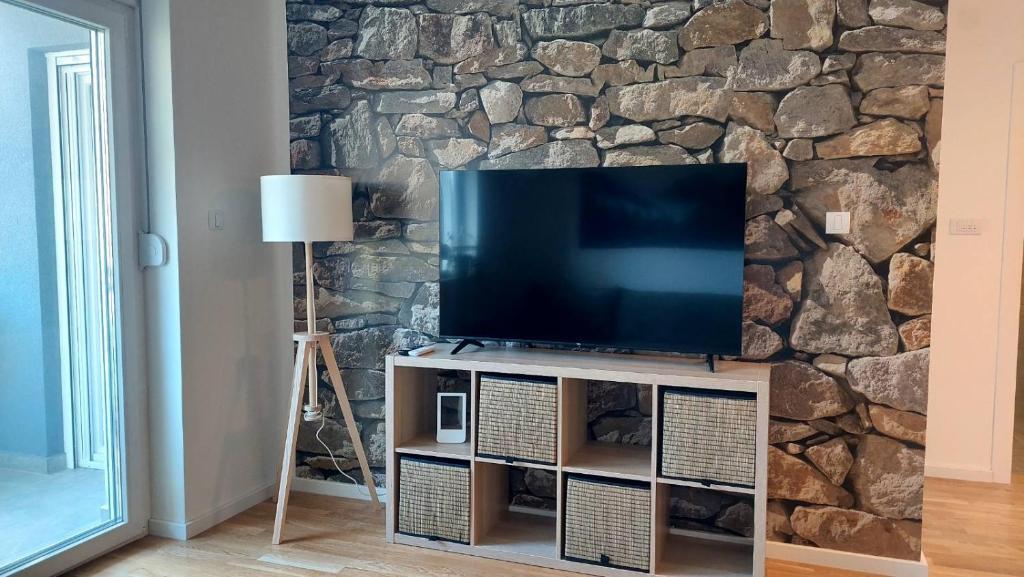 a flat screen tv on a stand in a living room at My Life 19 - Green Hill in Soko Banja