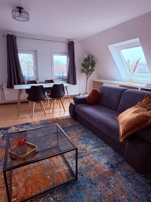 a living room with a blue couch and a table at Apartment DümmerSee in Hüde