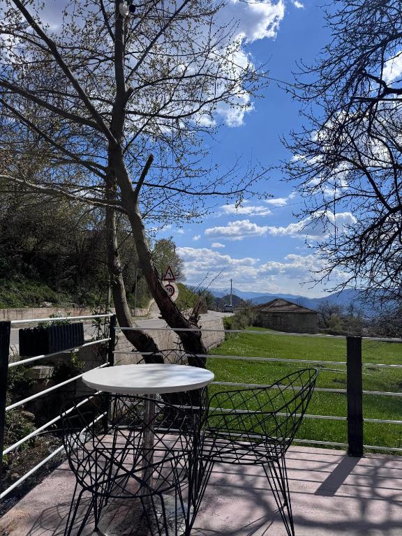 a table and chairs on a patio with a tree at Bujtina Destan Doda in Librazhd