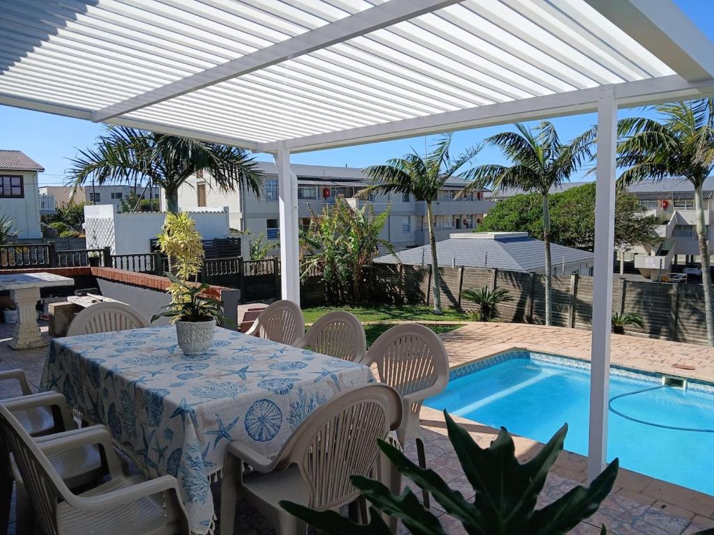 a patio with a table and chairs and a pool at Turtle's Nest in Margate