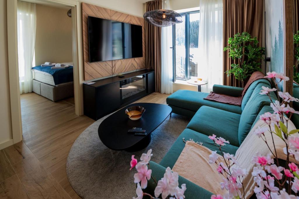 a living room with a couch and a table at SkyHill Jahorina Poljice Gondola in Jahorina