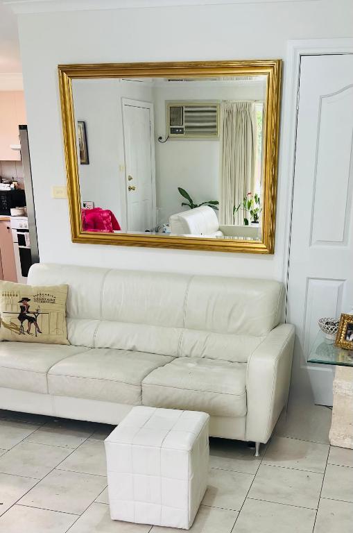 a white couch in a living room with a mirror at ABC Homes Nedlands in Doncaster East
