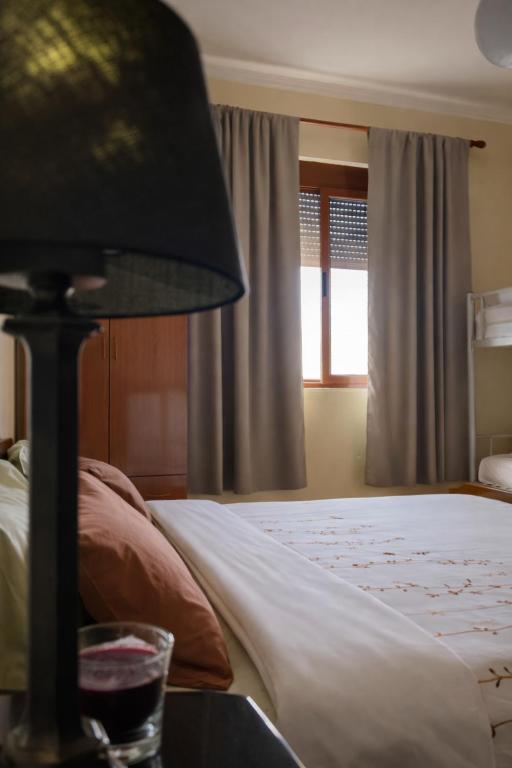 a bedroom with a bed and a lamp and a window at 3 Roots Villa in Krujë