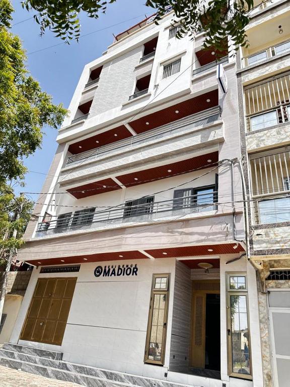 a white building with a balcony on the side of it at Résidence Madior D2 in Dakar