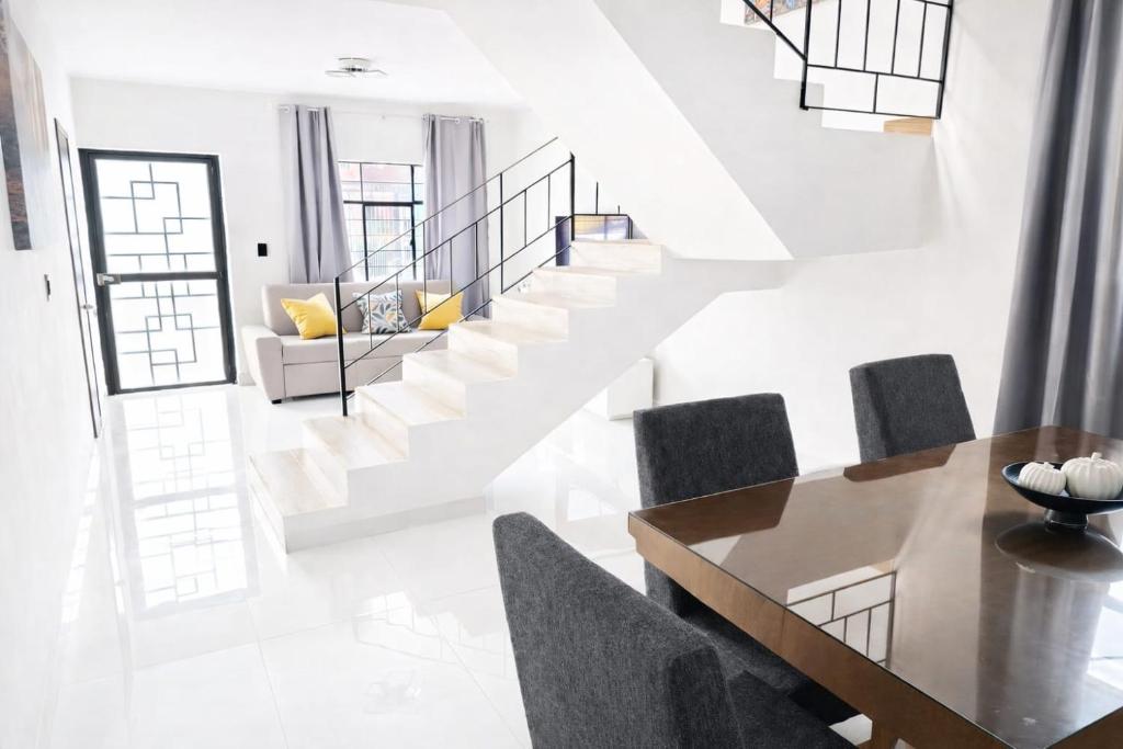 a dining room with a staircase and a table and chairs at Casa amplia para grupos Remodelada y centrica in Guadalajara