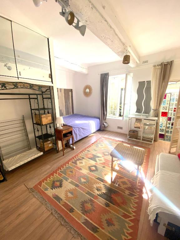a living room with a bed and a rug at MataDoora in Nîmes