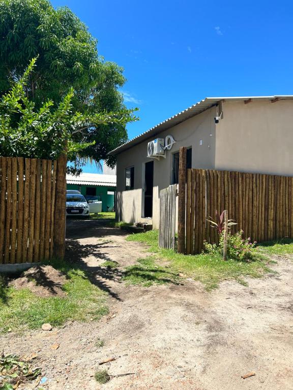 a wooden fence in front of a house at Casa do kell in Itaúnas