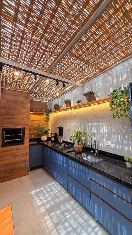 a large kitchen with blue cabinets and a sink at Flat aconchegante em Juquehy! Com piscina! in Praia de Juquehy