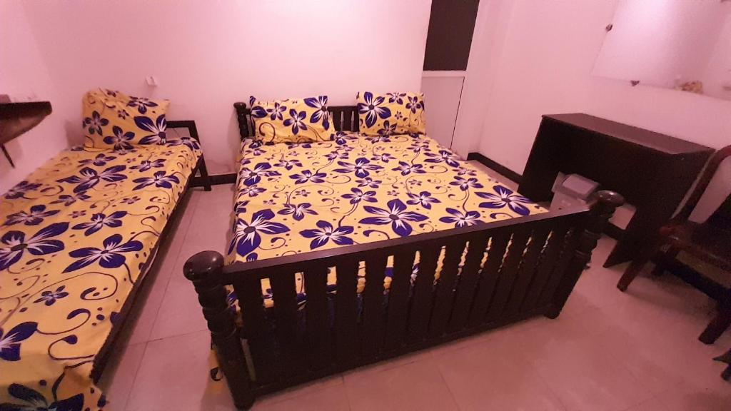 a bedroom with two beds with blue and white sheets at RR House in Colombo