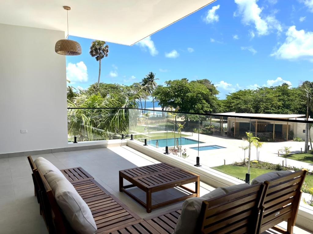 a living room with a couch and a table on a balcony at Beachfront Paradise - Huge Pool, Ocean View & Surf in Cabarete