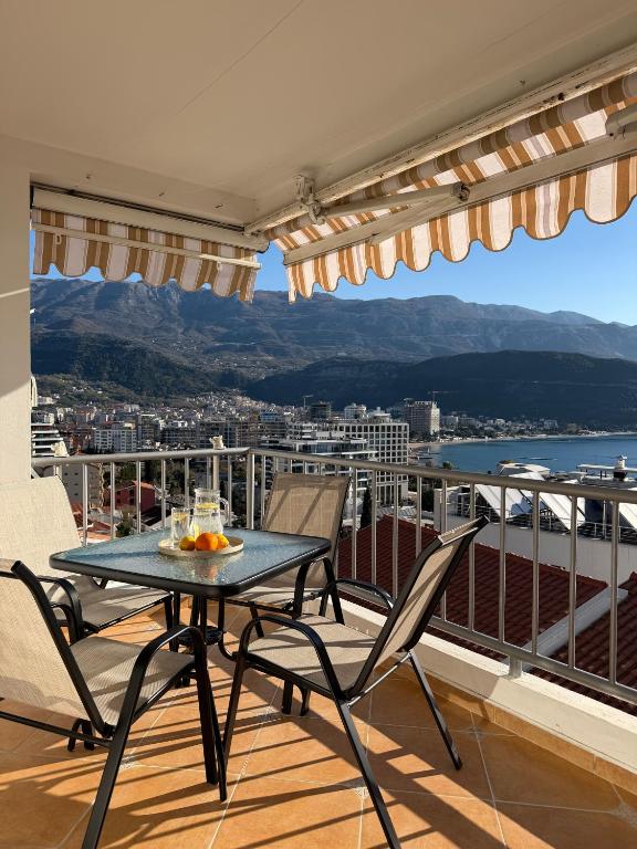 a table and chairs on a balcony with a view at Perla Sea View in Budva