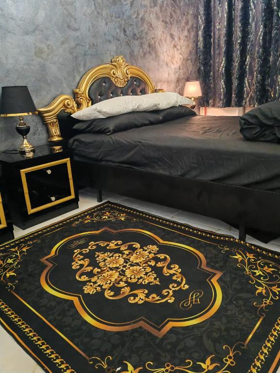 a bedroom with a bed with a black and gold rug at Baroque Palace Black Diamond in Arad