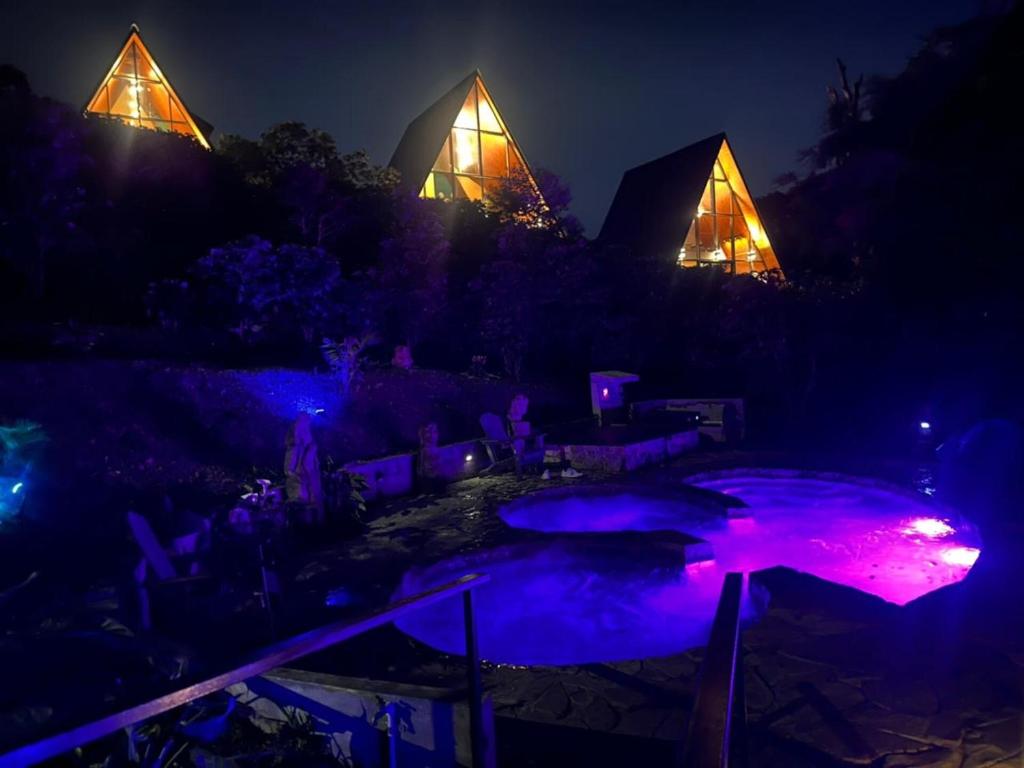 a group of pyramids lit up at night with purple lights at Coffee Cabins - Cabin 4 in Boquete