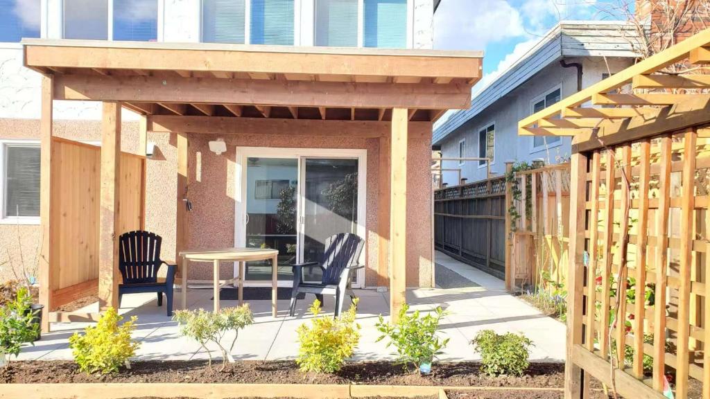 a pergola with two chairs and a table on a patio at Meet Cottage in Vancouver