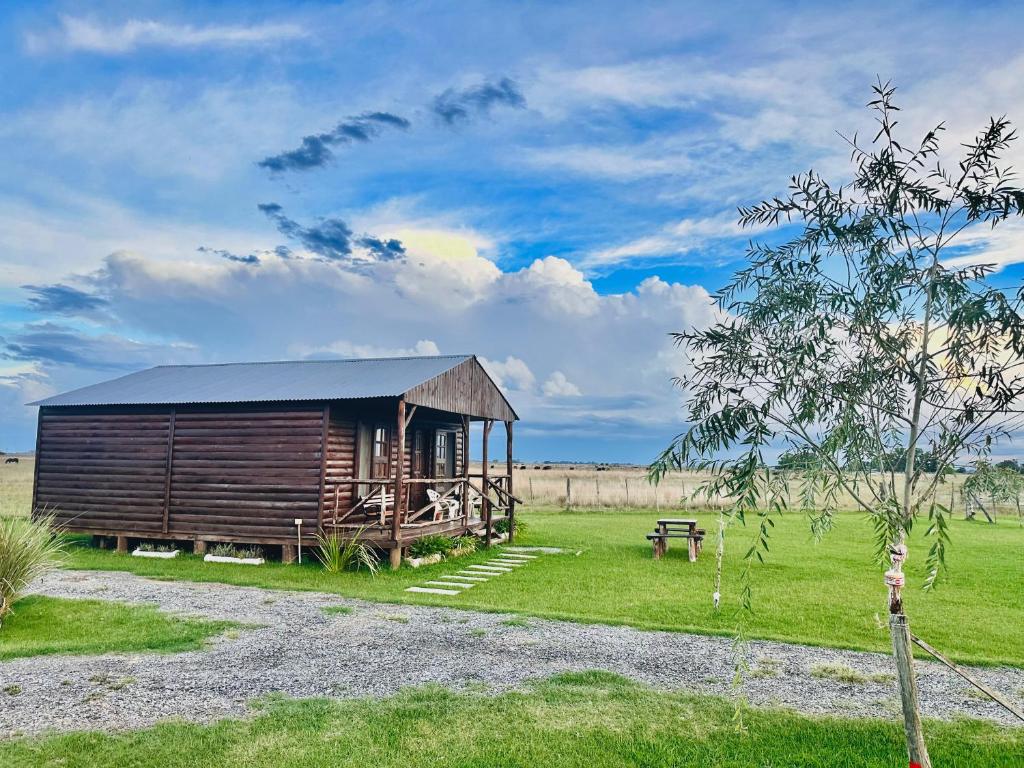 a wooden cabin in the middle of a field at Cabañas Las Escondidas 3 in Chascomús
