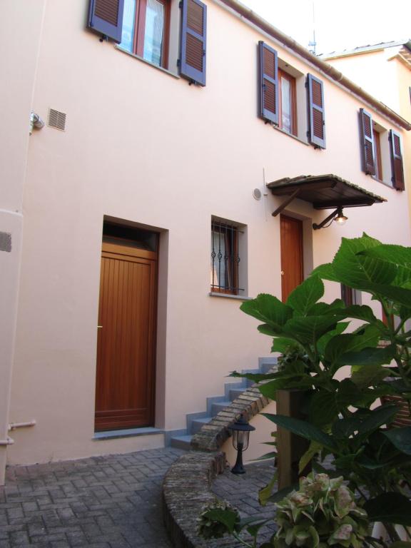 ein Gebäude mit einer Holztür und einer Treppe in der Unterkunft B&B La Casetta in Mondolfo