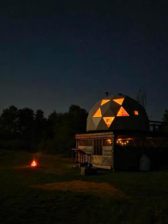 a dome tent sitting in a field at night at Prêt-à-camper, dôme in La Tuque