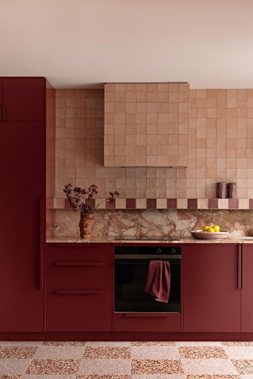 a kitchen with red cabinets and a red oven at Bon Bon Apt 2 - Rosa in Orange