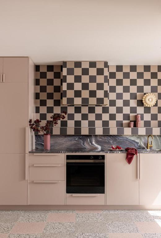 a kitchen with a checkered wall and a counter top at Bon Bon Apt 5 - Tonka in Orange