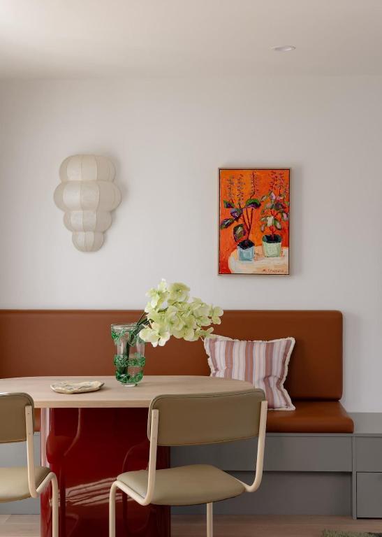 a dining room table with a vase of flowers on it at Bon Bon Apt 4 - Roca in Orange