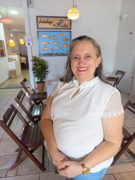 a woman standing in a room with her arms crossed at Pousada Aconchego em Mundaú in Trairi