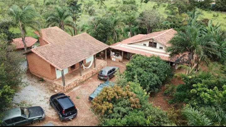a house with two cars parked in front of it at Luz da Serra Hospedagens in Santana do Riacho