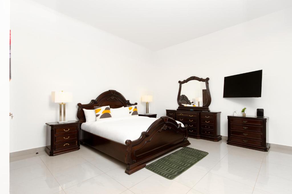 a bedroom with a bed and two dressers and a television at Hotel H4 El Paraíso in El Paraíso