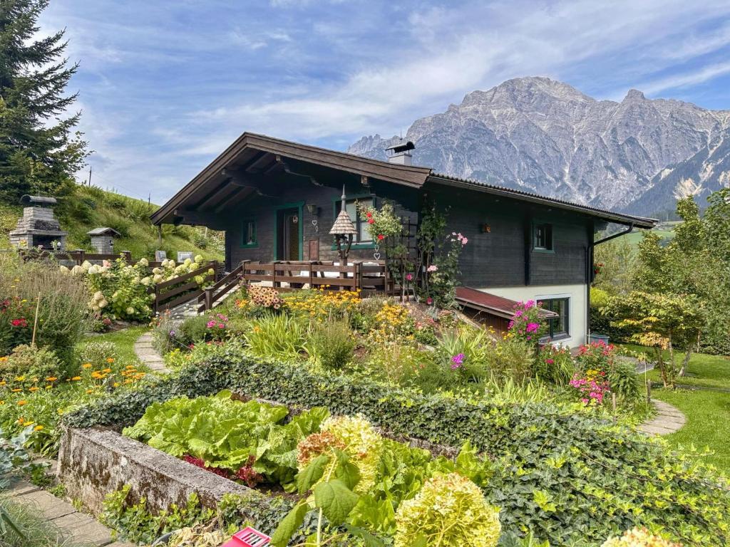 a garden in front of a house with mountains in the background at Madreit in Leogang
