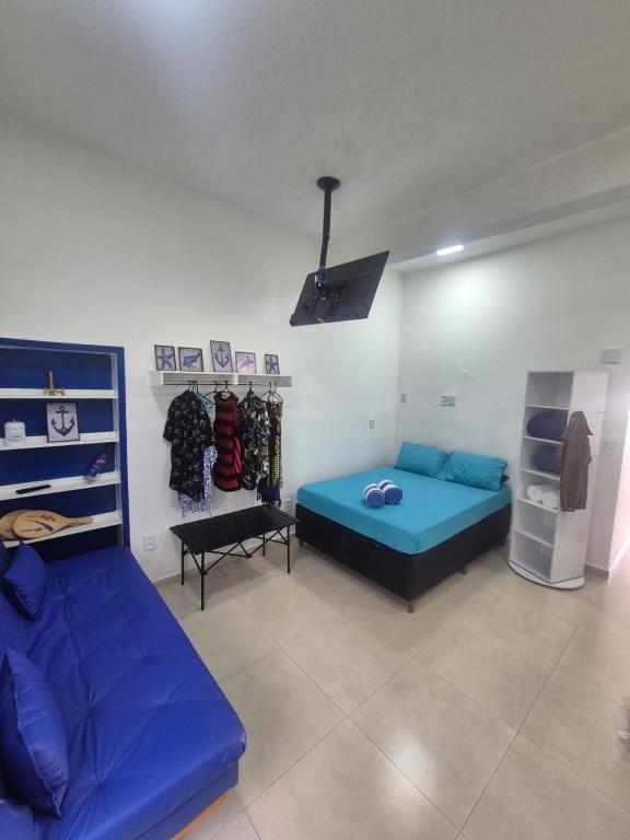 a living room with two beds and a couch at Aconchego do Caju in Arraial do Cabo
