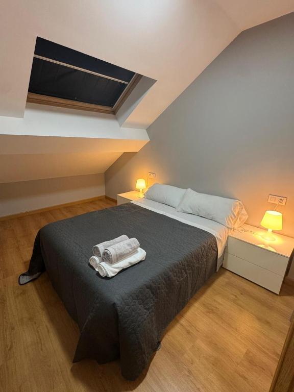 a bedroom with a bed with two towels on it at PASEO ROMANo in Lugo
