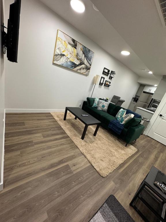 a living room with a green couch and a table at Private Stylish Suite, Just Bring Your Bags in Edmonton