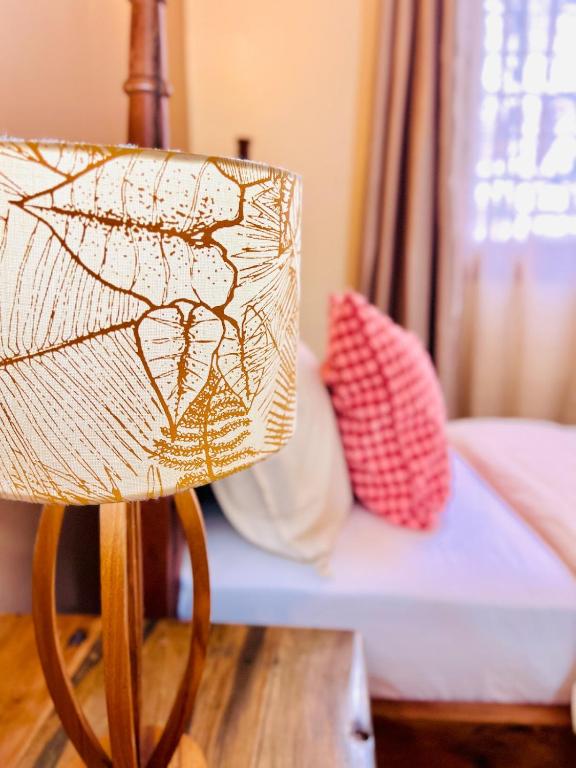a chair sitting in front of a bed at Nuru House Stone Town Ensuite 3BR Apartment in Zanzibar City