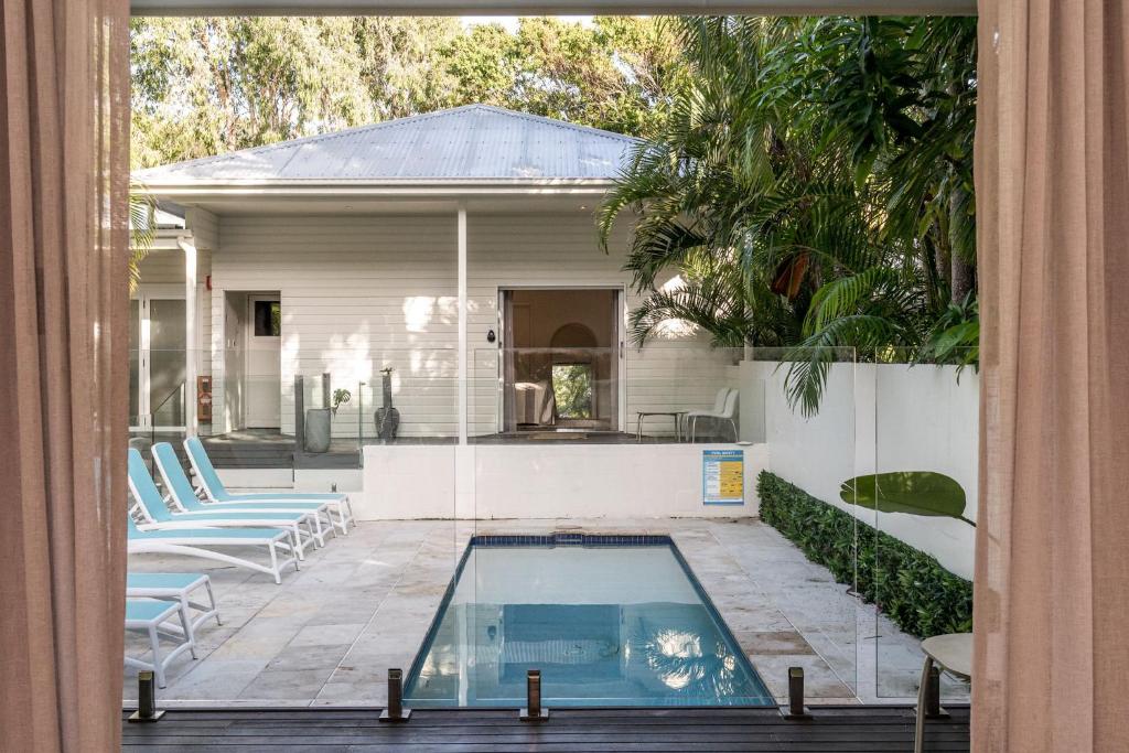 a swimming pool in front of a house at Cove Studios in Byron Bay