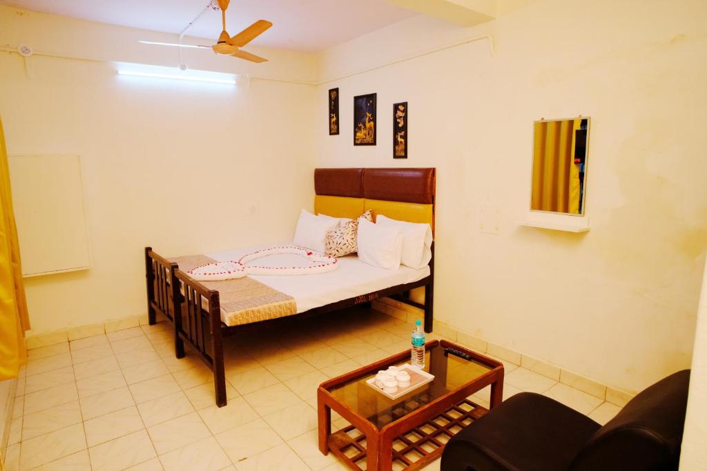 a small room with a bed and a table at Aruppukottai Nadar Lodge in Chennai