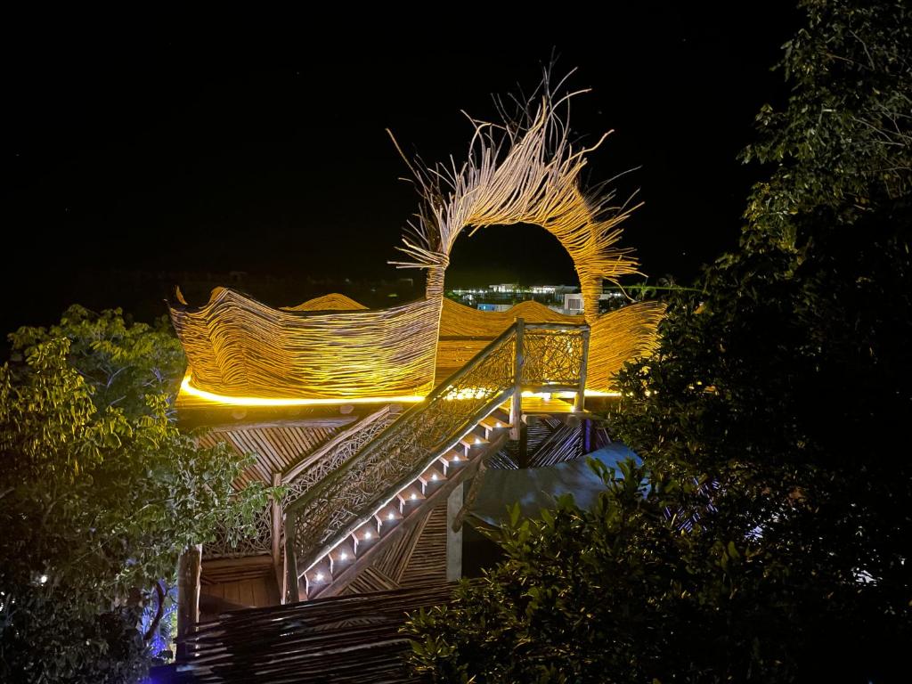 a night view of a building with a wooden structure at Villa Camila Tulum in Tulum