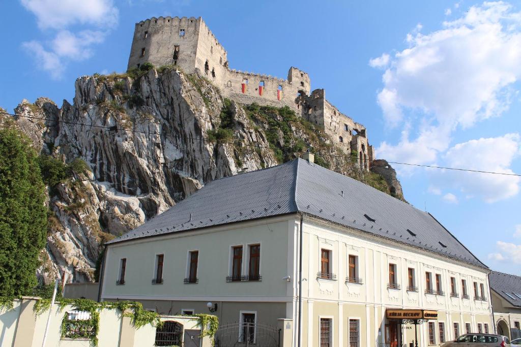 un edificio con un castillo en la cima de una montaña en Kúria Beckov - Penzión en Beckov