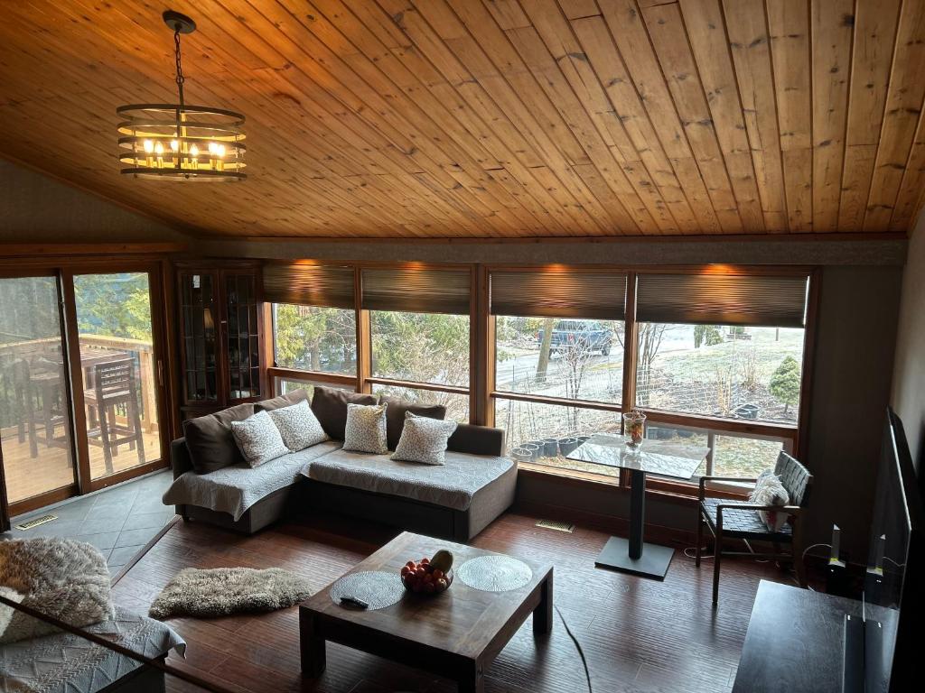 a living room with a couch and a table at Chalet Style, Lakeview Cottage in Bailieboro