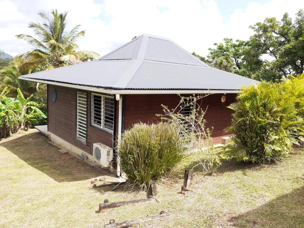 a small brown house with a tin roof at bungallow T2 Vernou in Petit-Bourg