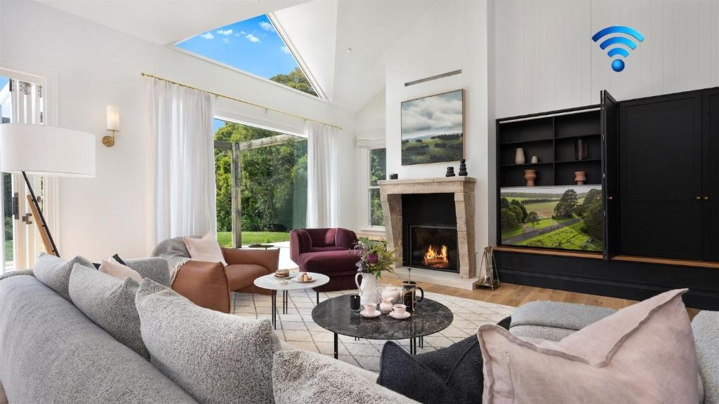 a living room with a couch and a fireplace at Burrawang House in Burrawang
